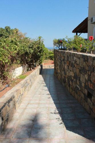 a stone walkway next to a stone retaining wall at Villa Medusa in Hersonissos