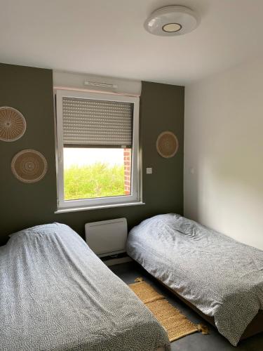 a bedroom with two beds and a window at Chez Aurel et Nico in Frélinghien
