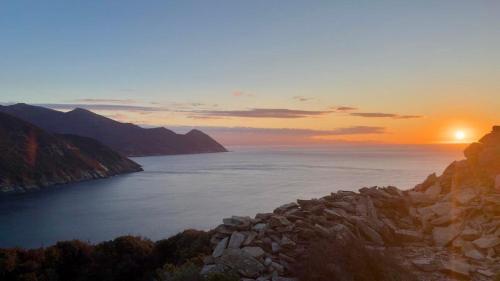 a sunset over a large body of water at Cap Hélios, vue mer à couper le souffle à Centuri in Morsiglia