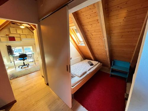 a small room with a bed and a hallway at Avenue 15 Boudry Suites and Studio in Boudry