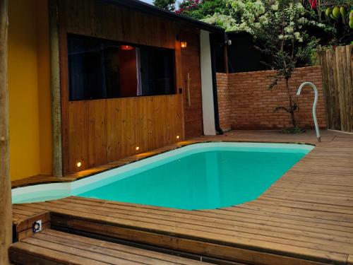 a swimming pool on a wooden deck next to a house at SuÍte MAR Espaço Kombucha Paraty in Paraty