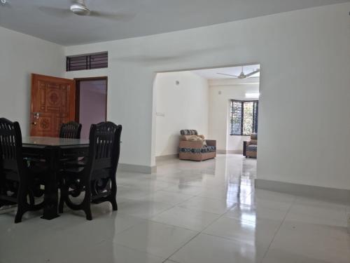 una sala da pranzo con tavolo e sedie neri di M Ali House a Sylhet
