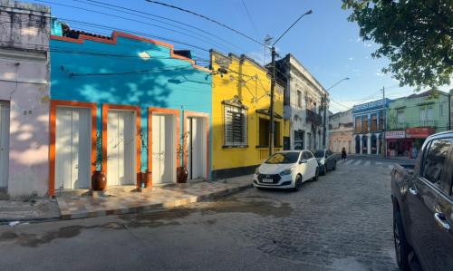 een witte auto geparkeerd aan de kant van een straat bij Pousada e Restaurante Morena Raiz in Olinda