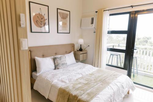a bedroom with a bed and a large window at Bright Modern Stay with Balcony & Ocean Breeze in Dao