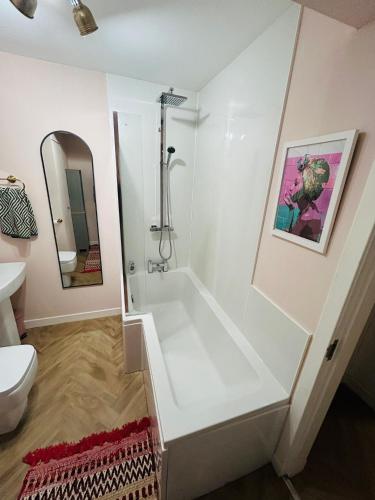 a white bathroom with a shower and a toilet at Four Seasons B&B, Ground floor room, private bathroom, 3rd floor loft living area & self serve continental breakfast in Pitlochry