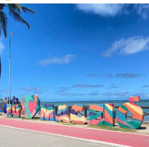 un muro di graffiti con l'oceano sullo sfondo di Pousada Hostel Beach Pajuçara a Maceió