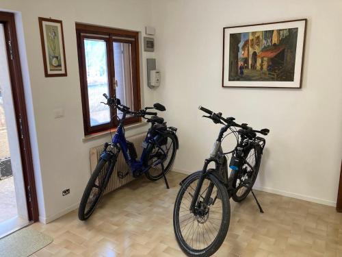 twee fietsen geparkeerd in een kamer naast een raam bij L'Intermezzo in Venzone