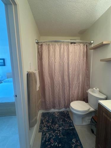 a bathroom with a shower curtain and a toilet at Island bliss apartment in Fajardo