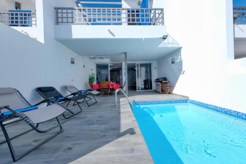 a house with a swimming pool and a balcony at Villa Mariña- Heated pool in Playa Blanca