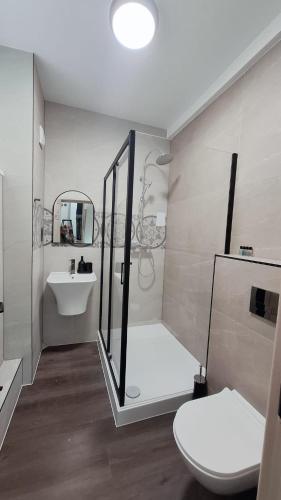 a bathroom with a toilet and a sink and a mirror at London Grand in London