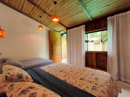 a bedroom with two beds and a window at SuÍte MAR Espaço Kombucha Paraty in Paraty