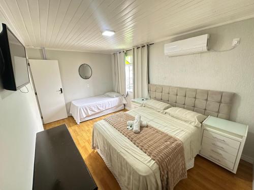 a bedroom with a large bed and a window at Suite em Hospedagem 100m da BR! in São José