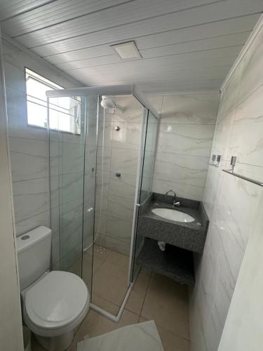 a bathroom with a toilet and a shower and a sink at Suite em Hospedagem 100m da BR! in São José