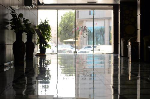 una hall con porta a vetri e pianta in vaso di Spring Tower ad Al Jubail