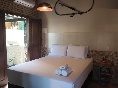 a bedroom with a bed with two towels on it at Studio Gamboa in Garopaba