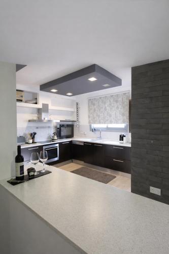 a large white kitchen with a large counter top at Blue Tulip - Strovolos in Kato Lakatamia