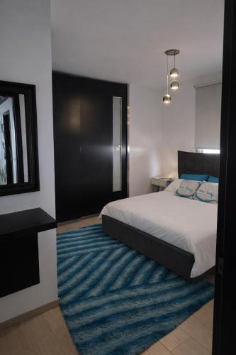 a bedroom with a bed and a blue rug at Blue Tulip - Strovolos in Kato Lakatamia