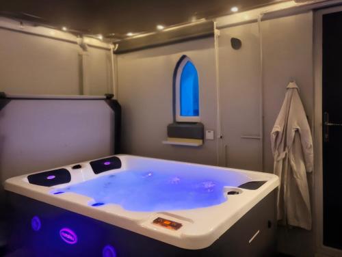 a large bath tub in a room with a window at Relaxing Coastal Retreat for 2 Hot Tub Log Fire in Tywyn