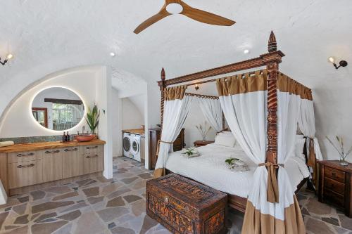 a bedroom with a canopy bed and a bathroom at Sunshine Coast Hinterland Igloo Retreat Romantic & Private in Flaxton