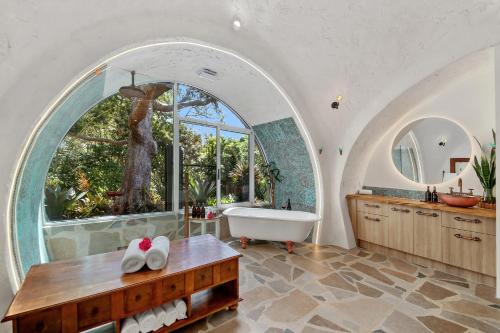 a bathroom with an arched window and a bath tub at Sunshine Coast Hinterland Igloo Retreat Romantic & Private in Flaxton