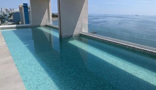a swimming pool with blue water in a building at HABITACIÓN Torres Palmas alberca, vista al mar, Roof Top VIP in Boca del Río