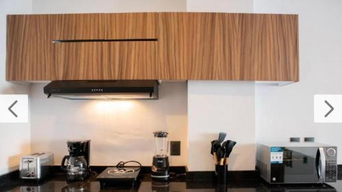 a kitchen with a counter top with a wooden cabinet at HABITACIÓN Torres Palmas alberca, vista al mar, Roof Top VIP in Boca del Río