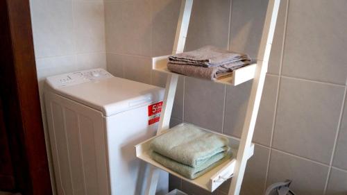 a small bathroom with a white refrigerator and towels at Apartment 24 modern & gemütlich in Dessau