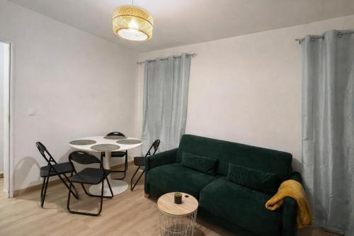 een woonkamer met een groene bank en een tafel bij 4 personnes - Proche Centrex et Disneyland in Noisy-le-Grand