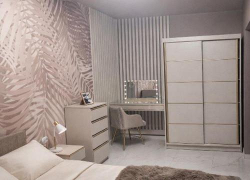 a bedroom with a bed and a desk and a dresser at Apartament Corner Cappuccino z wanną z hydromasażem w centrum Tomaszowa! Parliamo anche Italiano! in Tomaszów Mazowiecki