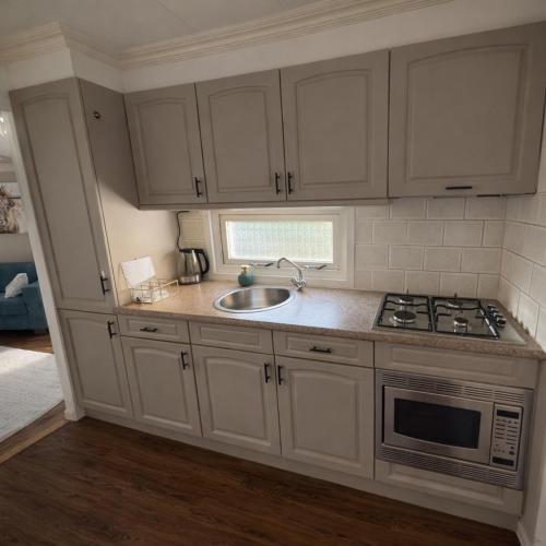 a kitchen with white cabinets and a sink at ViVe in Putten