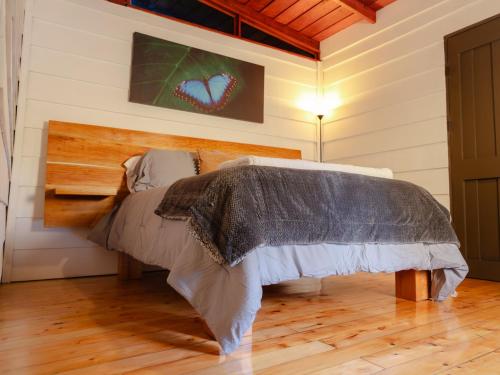 a bed in a room with a wooden floor at Nido de Montaña in Fraijanes