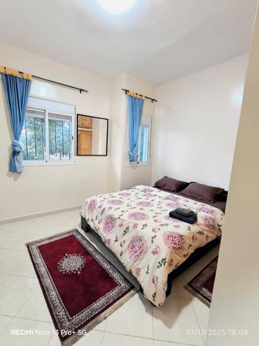 a bedroom with a bed and two rugs at Appartement in Mohammedia