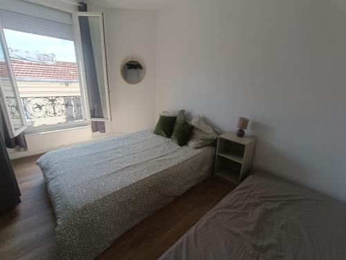 a white bedroom with a bed and a window at T2 Cosy 20 min Paris in Bezons