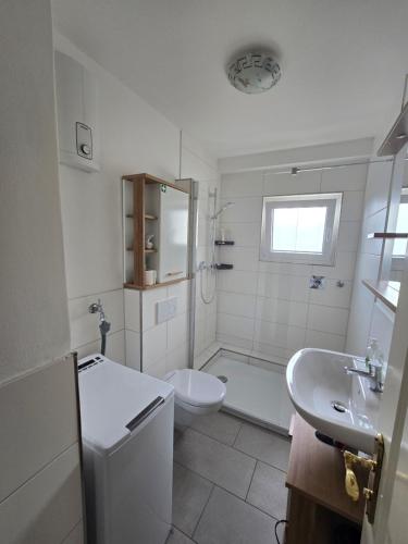 a white bathroom with a toilet and a sink at 3-Zimmer mitten in Siegburg in Siegburg