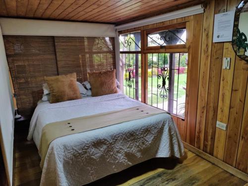 een slaapkamer met een bed in een kamer met een raam bij Los Vagones de William in Tibasosa