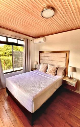 a bedroom with a large bed and a window at Arenal Stone House in Ángeles