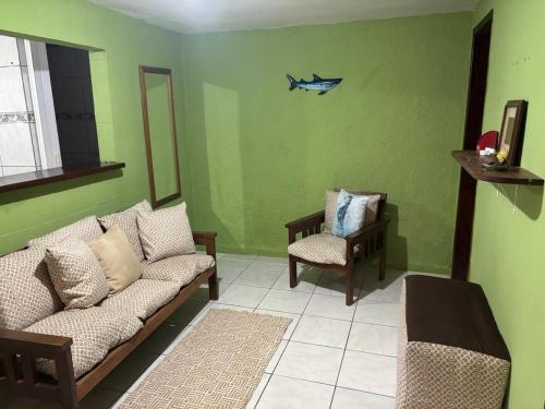 a living room with a couch and a fish on the wall at Jully''s house in Arraial do Cabo