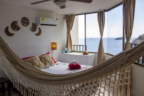 a hammock bed in a room with a view of the ocean at Apto Diners Rodadero WiFi - Piscina - Playa in Rodadero