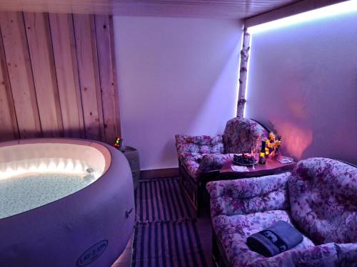 a bathroom with a tub and two chairs and a table at Domačija Vesel in Trebnje