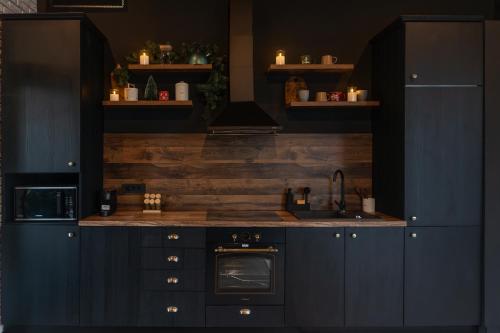 una cucina con mobili blu e un lavandino di Noma Cabin a Măguri