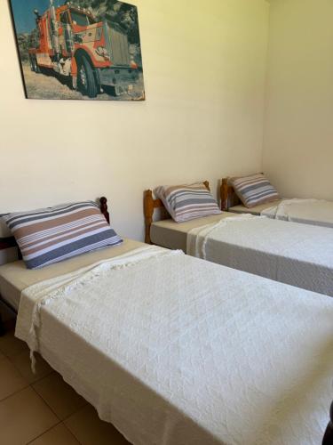 tre letti in una stanza con un trattore sul muro di Prudêncio Casas de Temporada a Torres