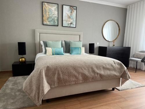 a bedroom with a large bed and a mirror at Full private 180sqm Villa - Terrace Jacuzzi - 200m Beach & Sea View in Albufeira