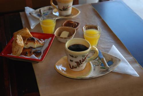 a table with a cup of coffee and a plate of food at La Aldea in San Rafael