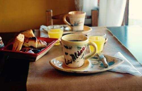 a table with two cups of coffee and a plate of food at La Aldea in San Rafael