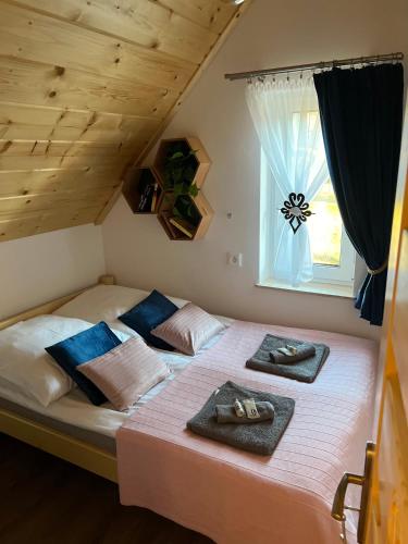 a bedroom with a bed with two towels on it at Odskocznia2 in Maniowy
