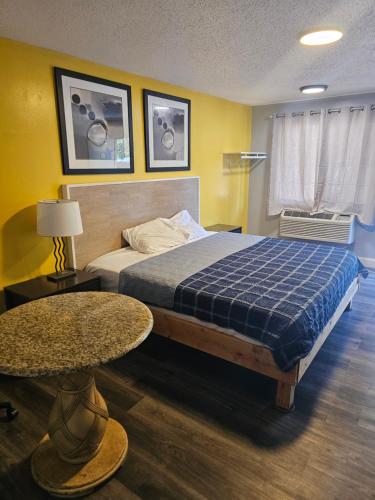 a bedroom with a bed and two tables in it at ScottishINN Galloway in Galloway
