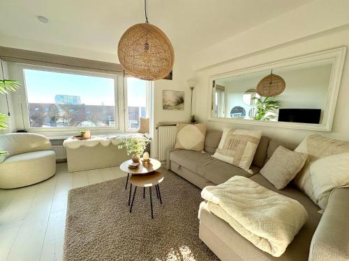a living room with a couch and a table at BEACH apartment met directe toegang tot het STRAND ! in Knokke-Heist