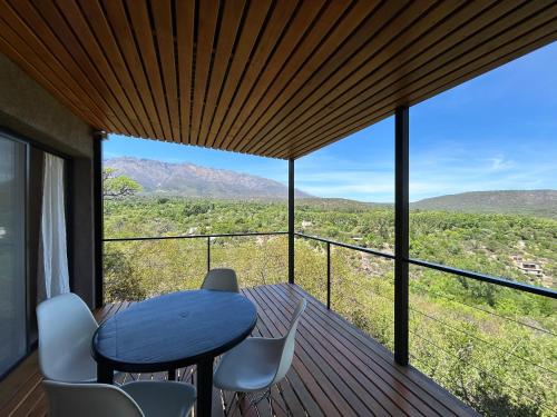 een tafel en stoelen op een terras met uitzicht bij Refugio de las Nubes in Las Rabonas