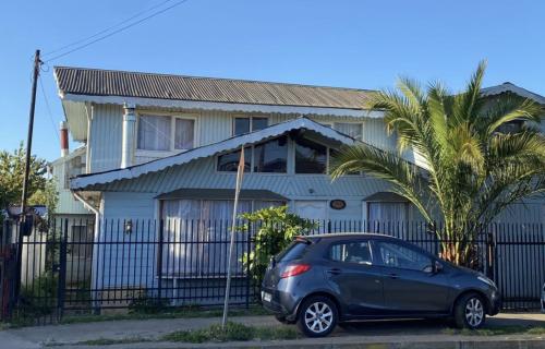 a small car parked in front of a house at Cabañas Casa Blanca in Valdivia
