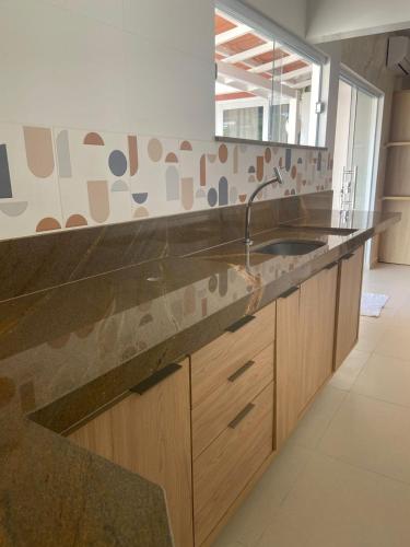 a kitchen with a large counter with a sink at Flat Sétima Arte in Cairu